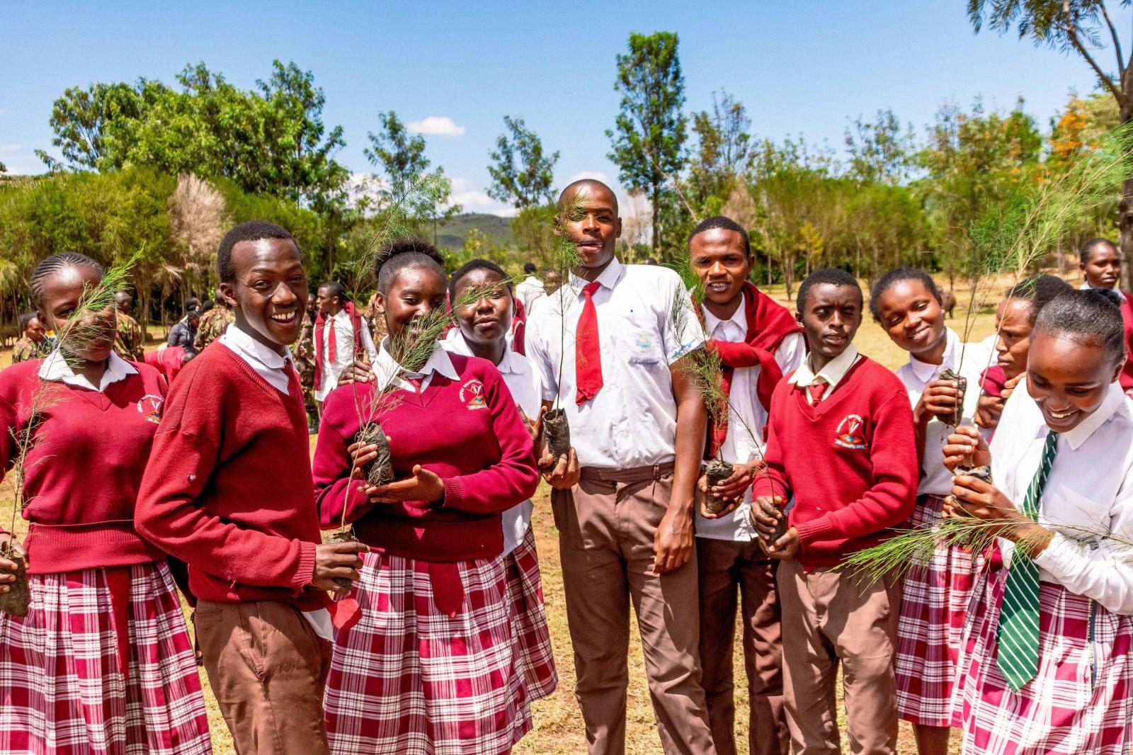 Students holding tree saplings